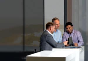 Guy, Grant and Vishu at standing desk looking at iPad